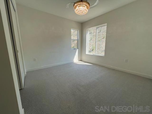 empty room with carpet and a chandelier