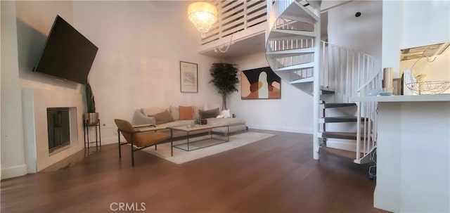 living area featuring stairway, dark wood finished floors, and baseboards