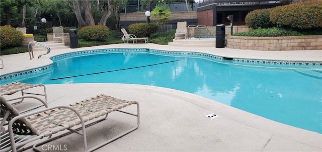 pool with fence and a patio