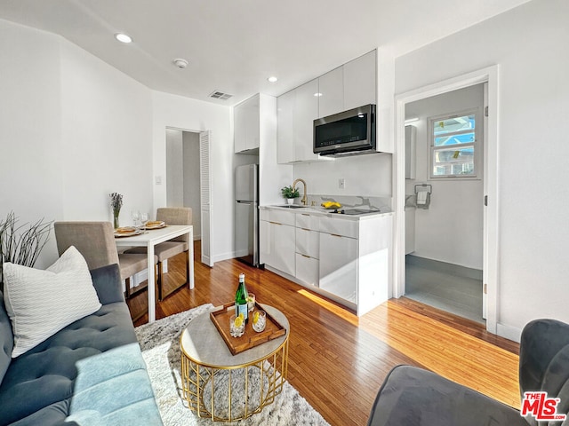 living room featuring light hardwood / wood-style floors and sink