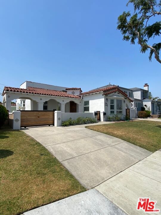 mediterranean / spanish-style home with a front lawn