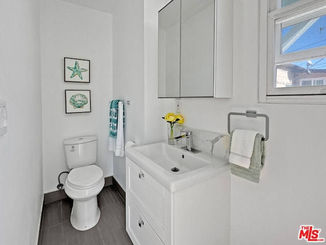 bathroom featuring vanity, toilet, and tile patterned flooring