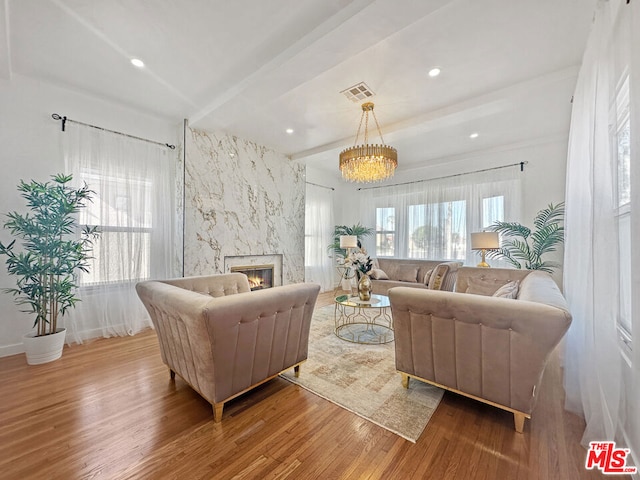 living room with beamed ceiling, hardwood / wood-style floors, and a fireplace