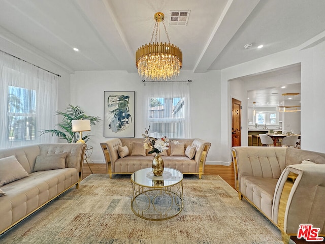 living room with an inviting chandelier, hardwood / wood-style flooring, and a healthy amount of sunlight