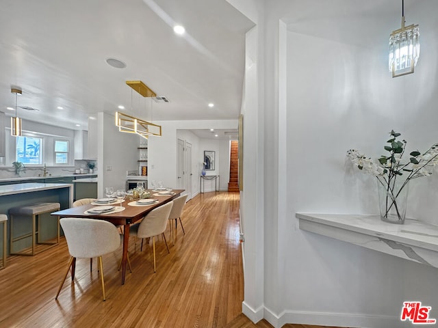 dining area with light hardwood / wood-style floors and sink