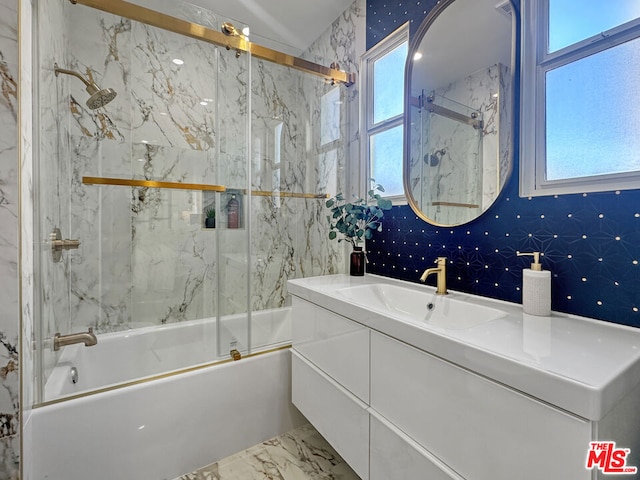 bathroom featuring vanity, a healthy amount of sunlight, and combined bath / shower with glass door