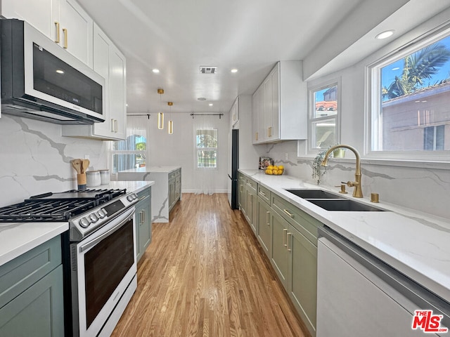 kitchen featuring sink, appliances with stainless steel finishes, white cabinetry, and light hardwood / wood-style floors