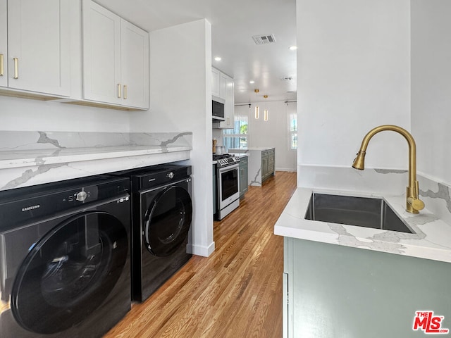 washroom featuring light hardwood / wood-style flooring, sink, and washing machine and dryer