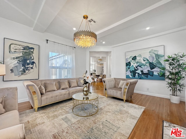 living room with beamed ceiling, hardwood / wood-style flooring, and an inviting chandelier