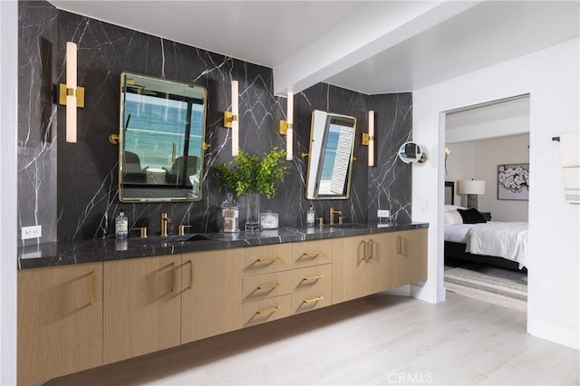 bathroom with wood-type flooring, vanity, and tasteful backsplash