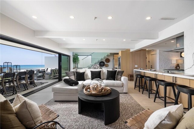 living room with beamed ceiling and a water view