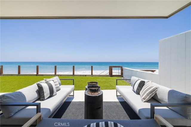 view of patio featuring outdoor lounge area, a water view, and a beach view