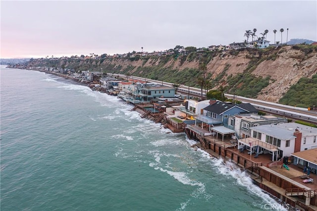 aerial view at dusk featuring a water view