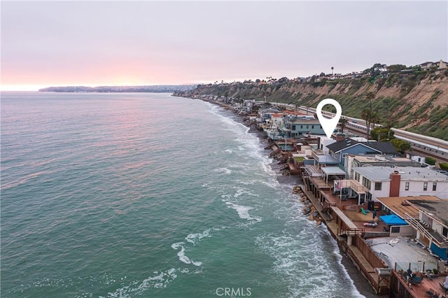 aerial view at dusk featuring a water view