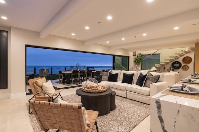 living room featuring beamed ceiling and a water view