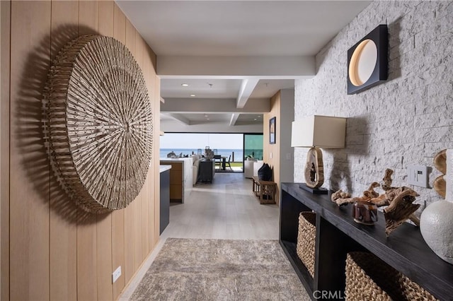 hallway featuring light hardwood / wood-style flooring and beamed ceiling