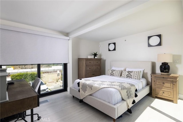 bedroom featuring beam ceiling and light hardwood / wood-style flooring