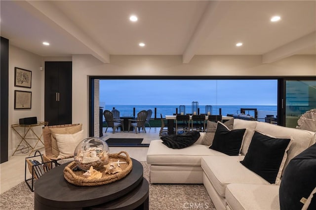 living room featuring beamed ceiling and a water view