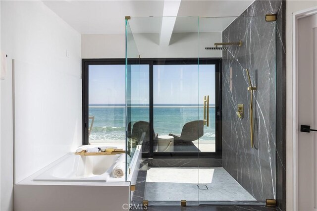 bathroom featuring an enclosed shower, a water view, and a wealth of natural light