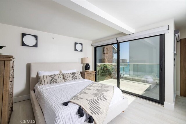 bedroom with beamed ceiling, light wood-type flooring, and access to outside