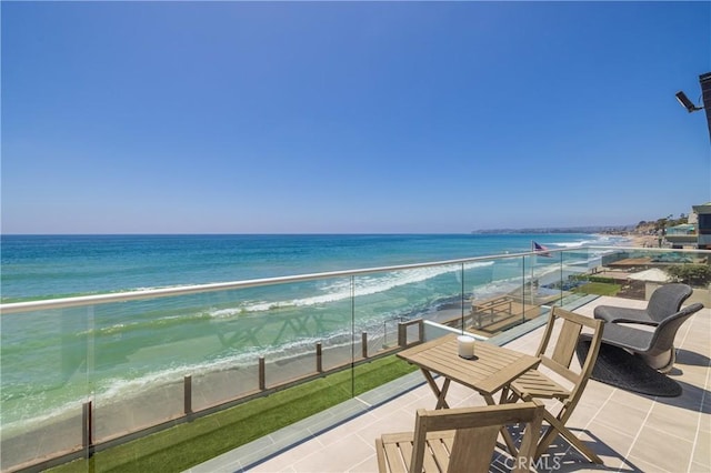 balcony featuring a beach view and a water view