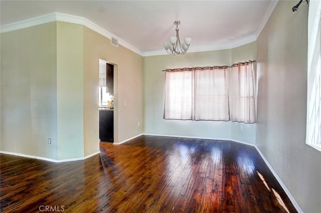 empty room with crown molding, dark hardwood / wood-style floors, and a chandelier