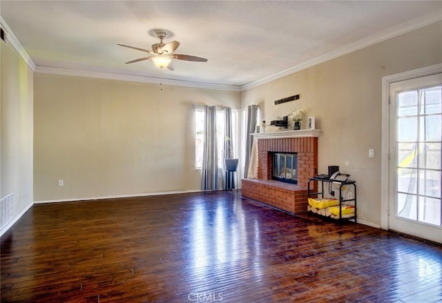 living room featuring ornamental molding, dark wood-type flooring, a fireplace, and a healthy amount of sunlight