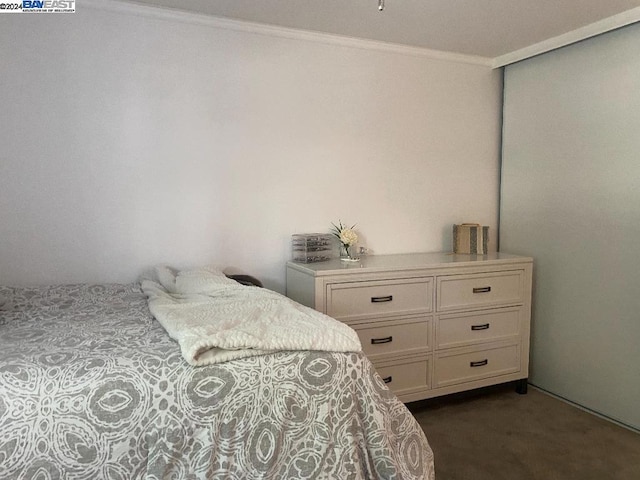 bedroom featuring ornamental molding and dark colored carpet