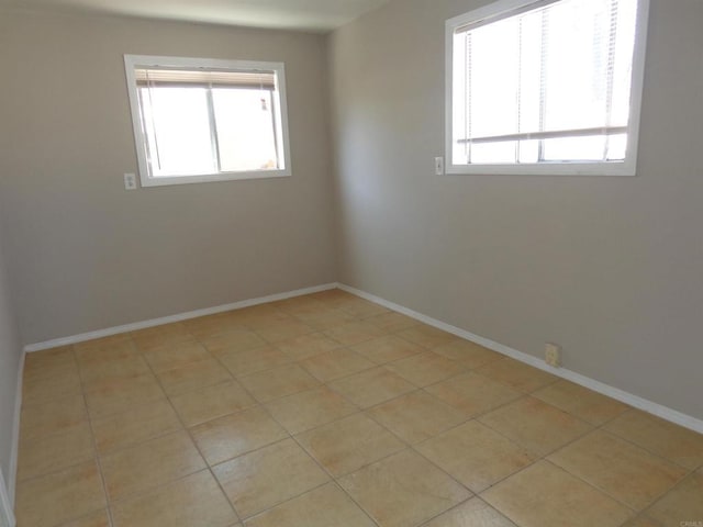 spare room with a healthy amount of sunlight and light tile patterned flooring