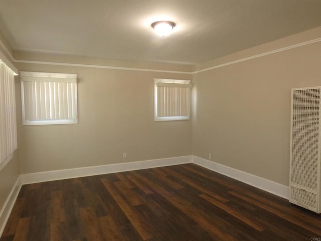 spare room with dark hardwood / wood-style floors and crown molding