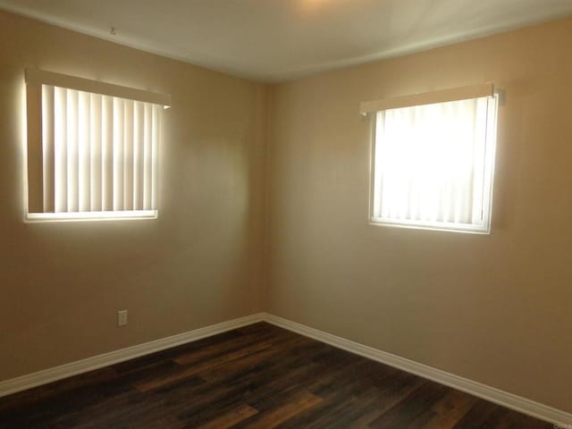 spare room with dark hardwood / wood-style flooring