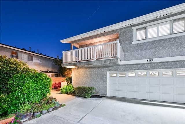 view of front of property featuring a garage and a balcony