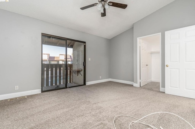 carpeted spare room with ceiling fan and lofted ceiling