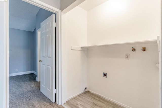 clothes washing area featuring hookup for an electric dryer and light hardwood / wood-style floors