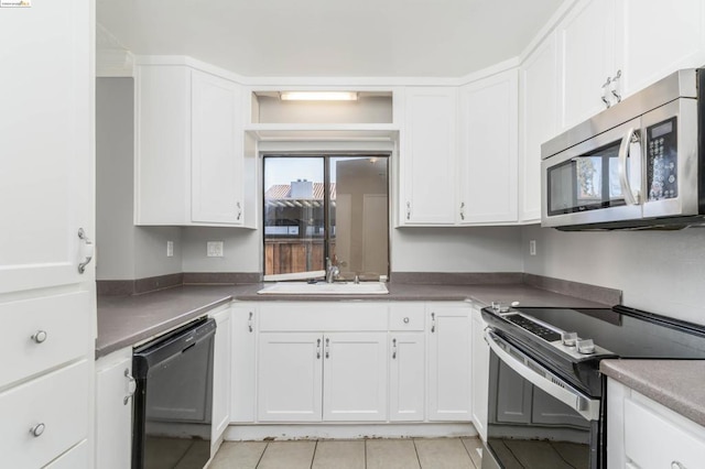 kitchen featuring white cabinetry, sink, light tile patterned flooring, and stainless steel appliances