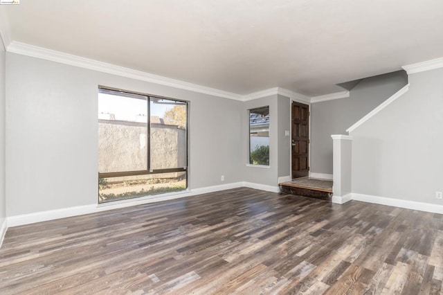 unfurnished living room featuring a wealth of natural light, crown molding, and dark hardwood / wood-style floors