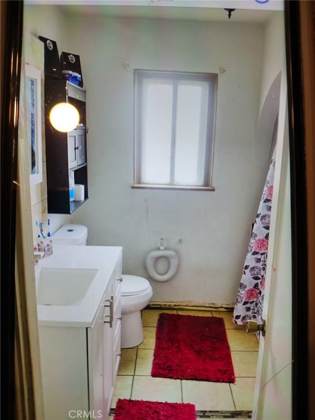 bathroom featuring toilet, tile patterned flooring, and vanity