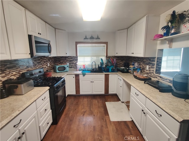 kitchen featuring decorative backsplash, gas stove, white cabinetry, and dark hardwood / wood-style flooring