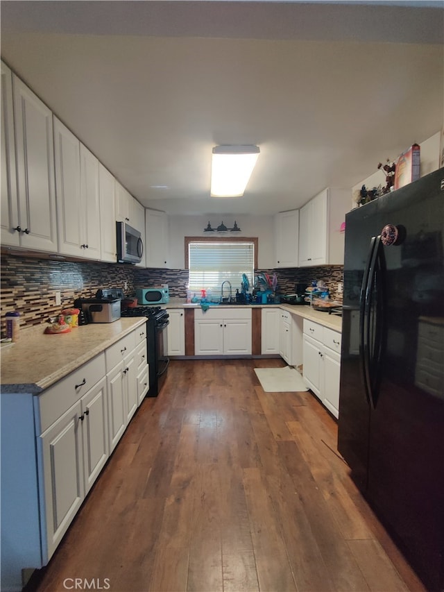 kitchen featuring stainless steel appliances, white cabinetry, and dark hardwood / wood-style flooring