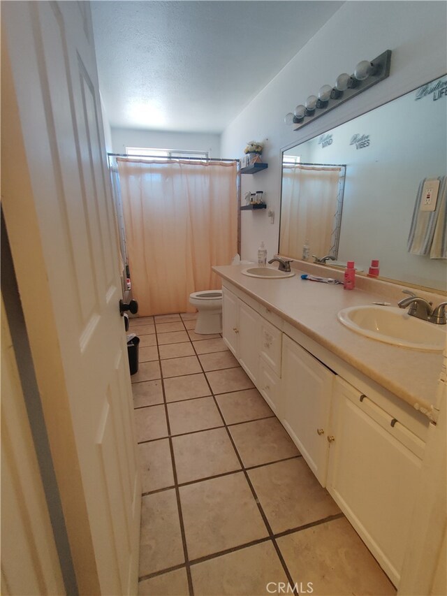 bathroom featuring vanity, tile patterned flooring, and toilet