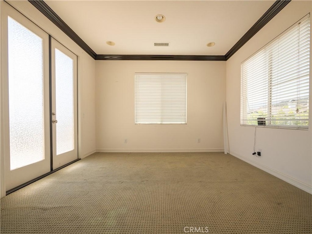 unfurnished room with crown molding, a healthy amount of sunlight, and light carpet