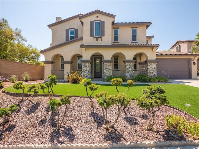 mediterranean / spanish-style house featuring covered porch, a garage, and a front lawn