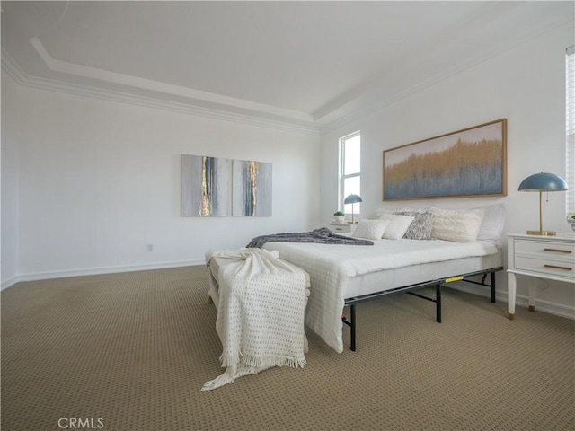 bedroom with a tray ceiling, crown molding, and carpet