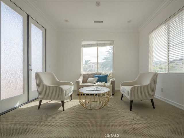 sitting room featuring crown molding and light colored carpet