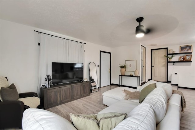 living room featuring light hardwood / wood-style flooring and ceiling fan