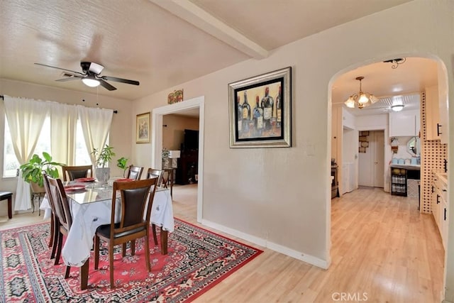 dining area with beam ceiling, light hardwood / wood-style flooring, and ceiling fan