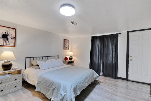 bedroom featuring a textured ceiling and light hardwood / wood-style floors