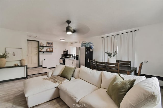 living room with light hardwood / wood-style floors and ceiling fan