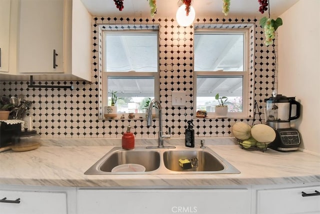 kitchen with sink, white cabinets, and decorative backsplash