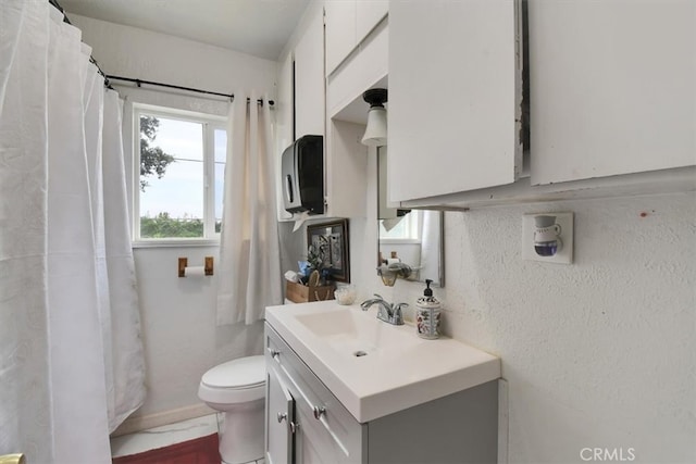 bathroom featuring vanity, curtained shower, and toilet